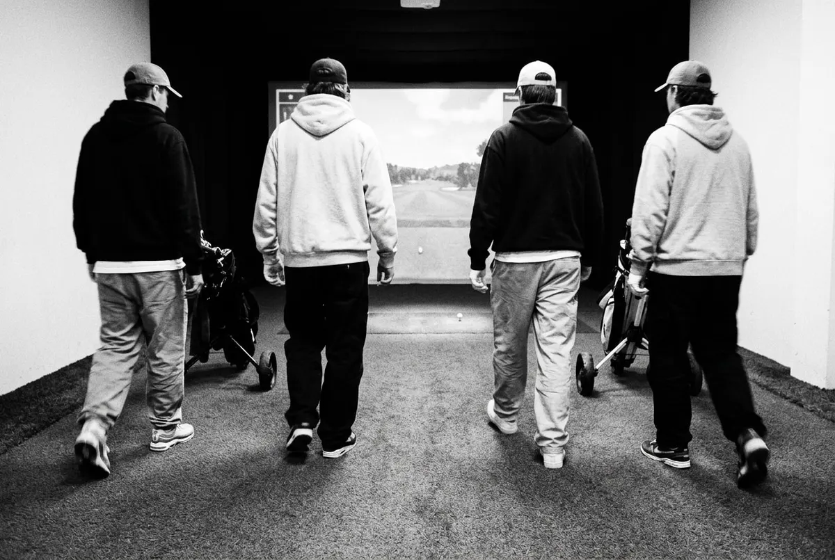 Vier golfers lopen samen naar één bal op de fairway, voor ze ieder hun eigen bal verder spelen