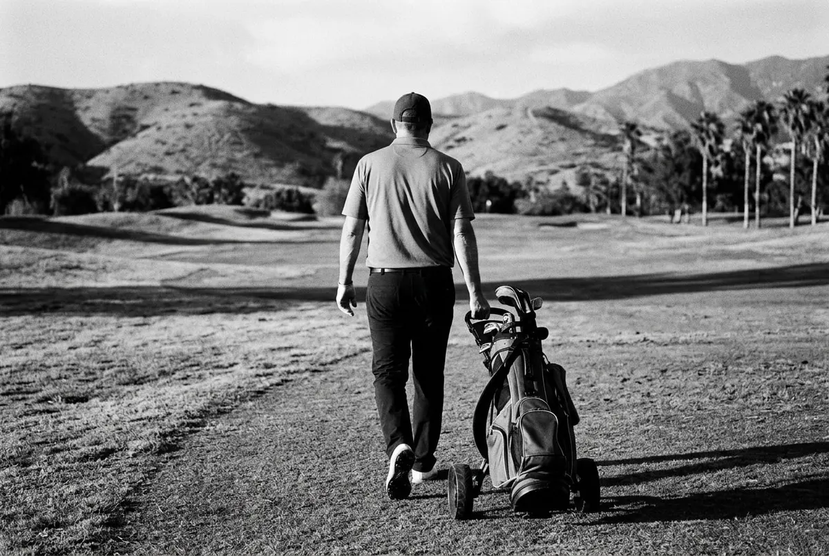 Golfer van achteren op een stille baan in Los Angeles bij laagstaande zon