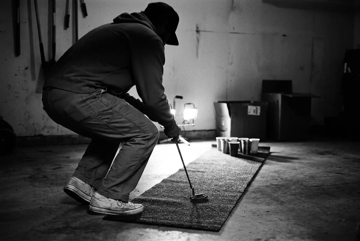 Putting mat met bekers in een huiskamer, iemand buigt zich voorover om te putten