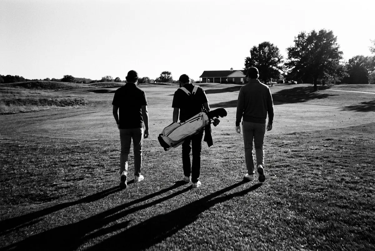 Drie golfers lopen samen over de fairway tijdens een rondje Amerikaantje