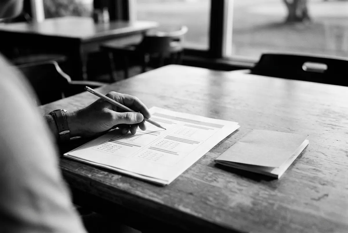 Een examenformulier met potlood op een tafel in het clubhuis, voorbereiding op het golfregelexamen