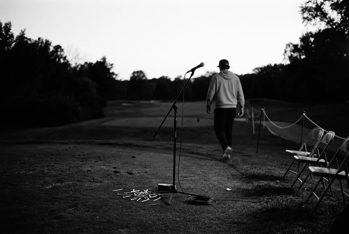 Lege microfoonstandaard bij de eerste tee van een golfbaan in de schemering