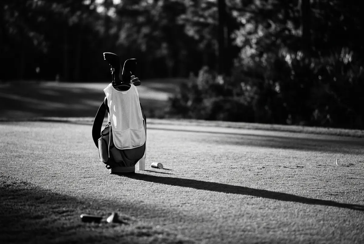 Een golftas met wit caddiehesje alleen op de fairway bij avondlicht