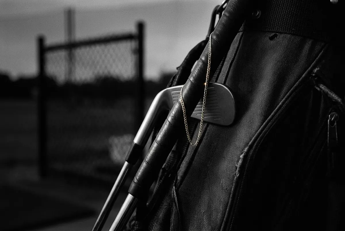 Golfclub met een gouden ketting eromheen, symbool voor de kruisbestuiving tussen golf en streetwear