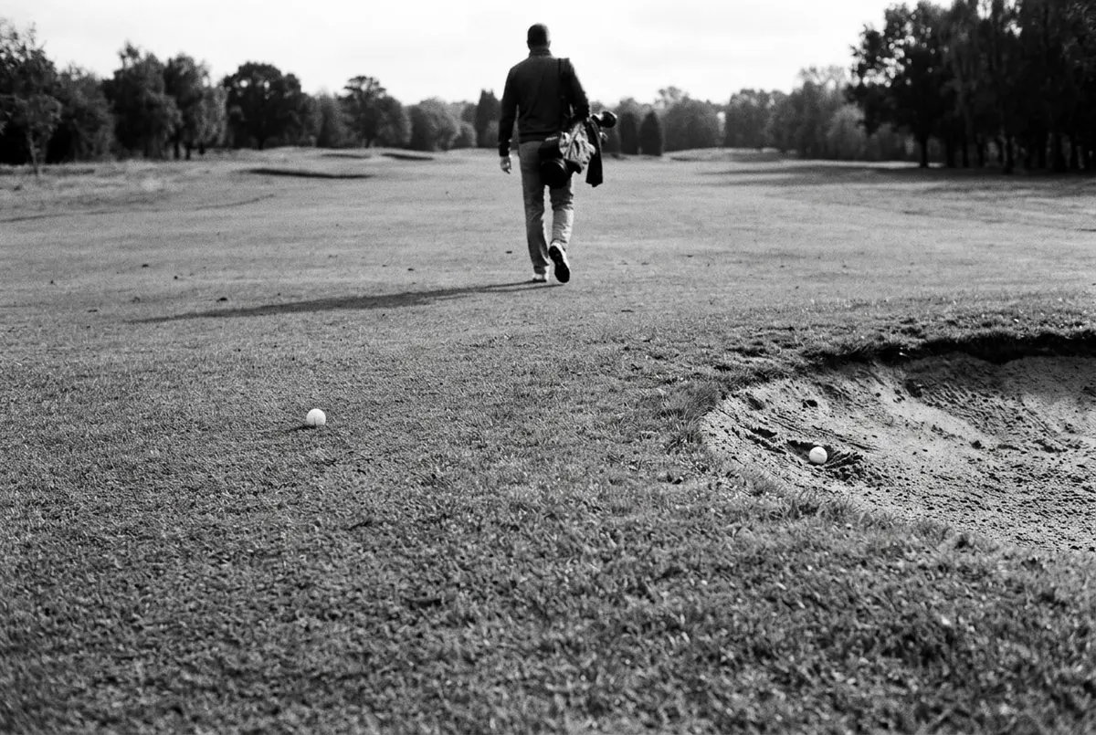 Twee golfballen op verschillende plekken op de fairway, één in het gras en één in een bunker